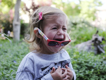 Cute girl crying against plants