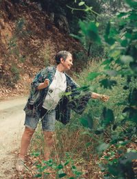 Elderly woman gathering plants in the nature. senior woman enjoying time in the forrest.