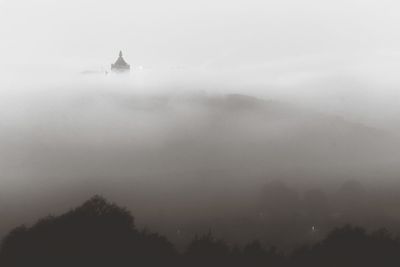 Scenic view of landscape against sky during foggy weather