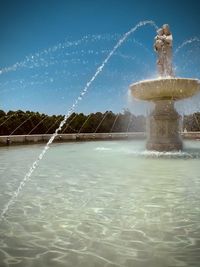 Water splashing fountain against sky