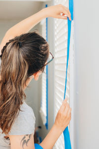 Rear view of woman standing against white wall