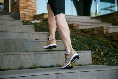 Low section of person wearing high heels on footpath