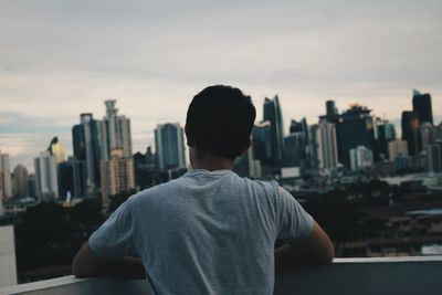 Rear view of man looking at cityscape