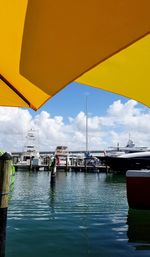 Sailboats moored on sea against sky