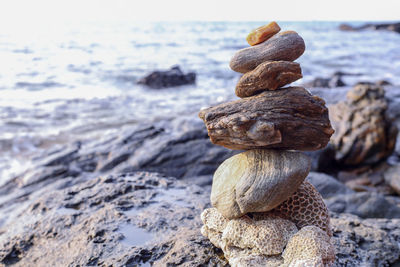 Close-up of stone stack on rock at beach