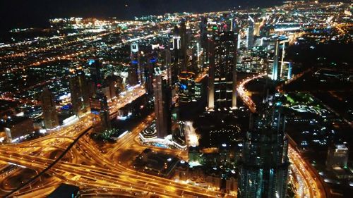 Aerial view of illuminated cityscape against sky at night