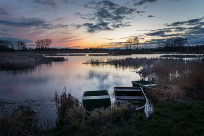 Boats on the shore of a quiet lake, view after sunset