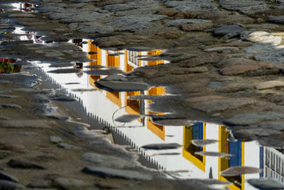 Reflection of yellow and historic building on rock