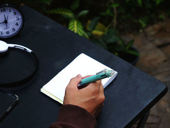 High angle view of person reading book on table