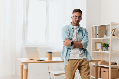 Portrait of young man standing in office