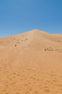 Scenic view of desert against clear blue sky