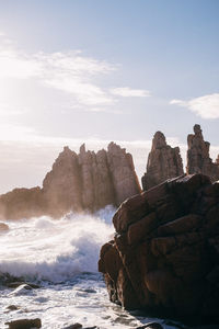 View of calm sea against rocky mountains