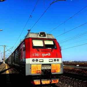 Train on railroad tracks against clear blue sky