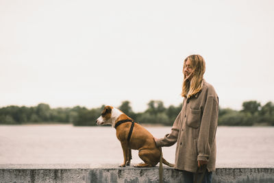 Side view of woman with dog against lake