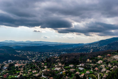 Aerial view of townscape and mountains against sky