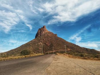 Road by mountain against sky