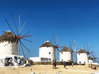 Traditional windmills in mykonos against clear blue sky