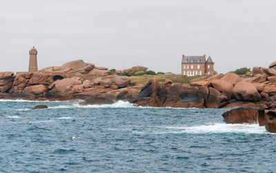 Scenic view of sea and rocks against clear sky