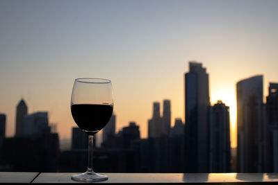 Close-up of wine glass against clear sky during sunset