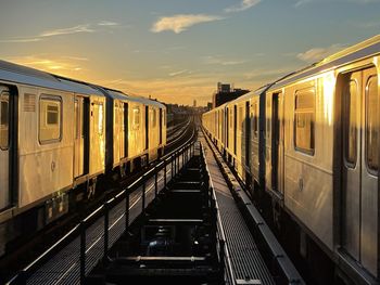 Train at railroad station against sky during sunset