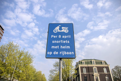 Low angle view of road sign against sky