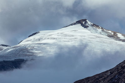 Low angle view of snowcapped mountains against sky