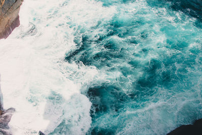 High angle view of waves splashing on rocks