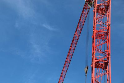 Low angle view of crane against blue sky