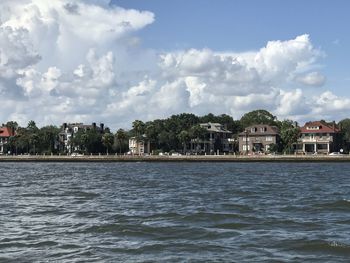 Scenic view of sea by buildings against sky