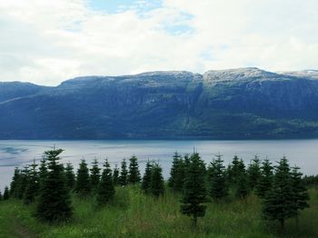 Scenic view of lake by mountains against sky