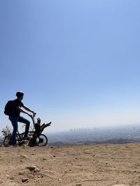 Man sight seeing los angeles while riding electric bicycle  uphill at hollywood sign trail. 