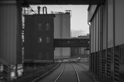 Railroad tracks amidst buildings in city against sky