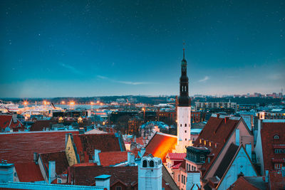 Illuminated cityscape against sky at night