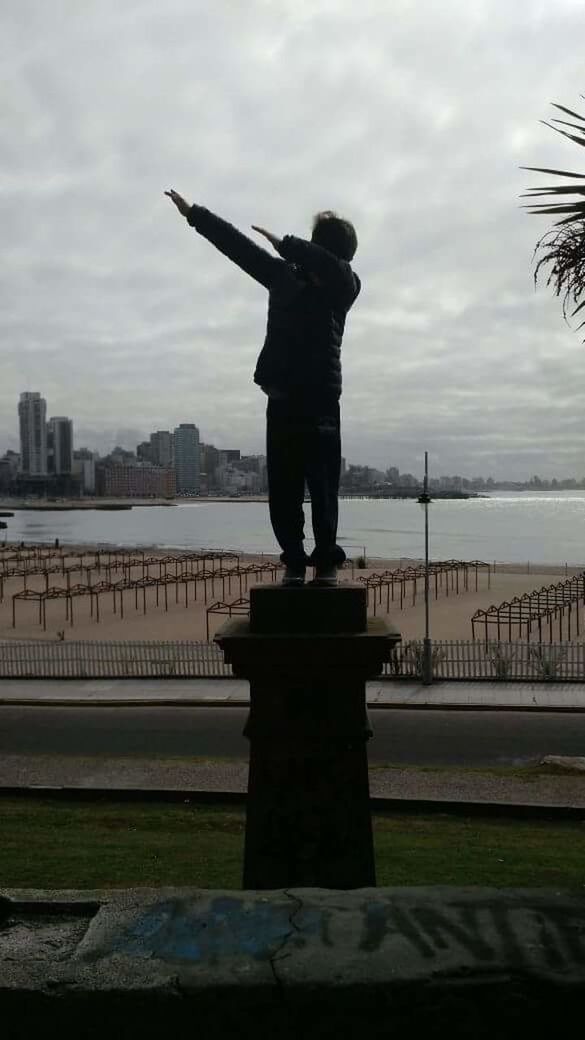 STATUE OF MAN STANDING AT RIVERBANK