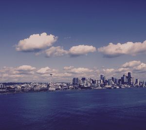 Sea by cityscape against sky