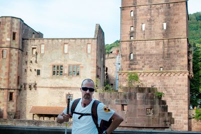 Full length portrait of man standing against building