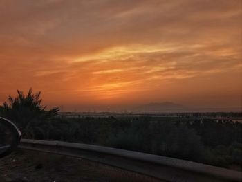 Scenic view of landscape against orange sky