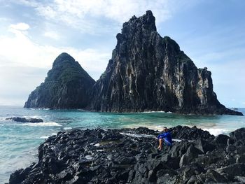 Rock formation on beach against sky