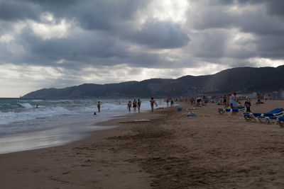 Group of people on beach against sky