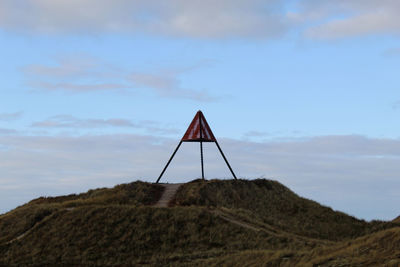 Lifeguard hut on land against sky