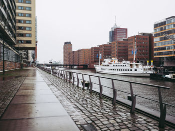 Boats moored at harbor against buildings in city