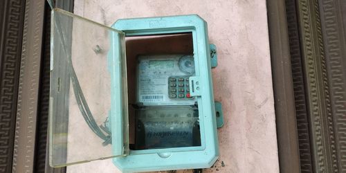 Close-up of old telephone booth against wall