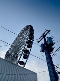 Low angle view of ferris wheel against clear blue sky