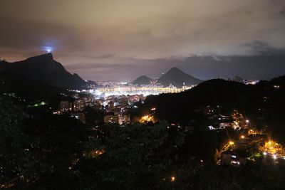 Illuminated cityscape against sky at night