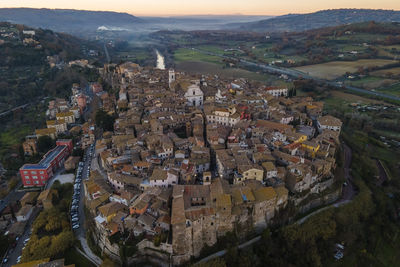 Aerial view of orte, a small town on hilltop along the tiber river at sunset, viterbo, italy.