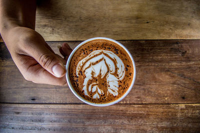 Directly above shot of hand picking coffee cup