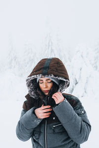 Young woman wearing hat standing in snow
