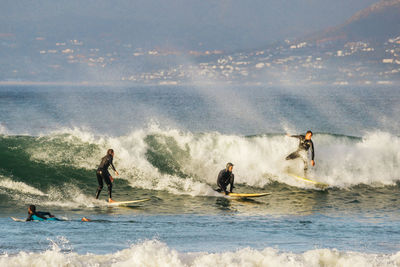 People enjoying in sea against sky