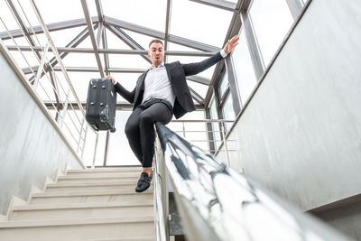 Low angle view of man sliding on railing