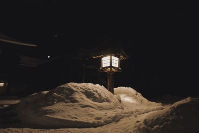 Low angle view of illuminated snowcapped mountain against sky at night